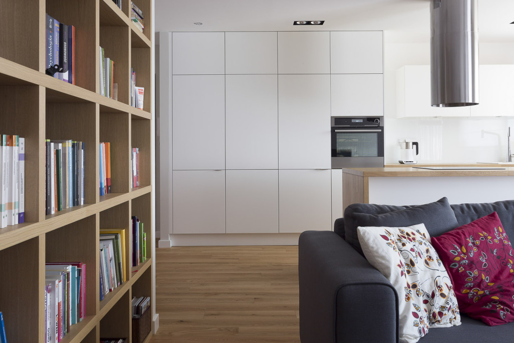 minimalizm biała kuchnia etno akcenty poduszki z haftem biblioteczka styl ludowy livingroom pokój z kuchnią salon z kuchnią szara kanapa