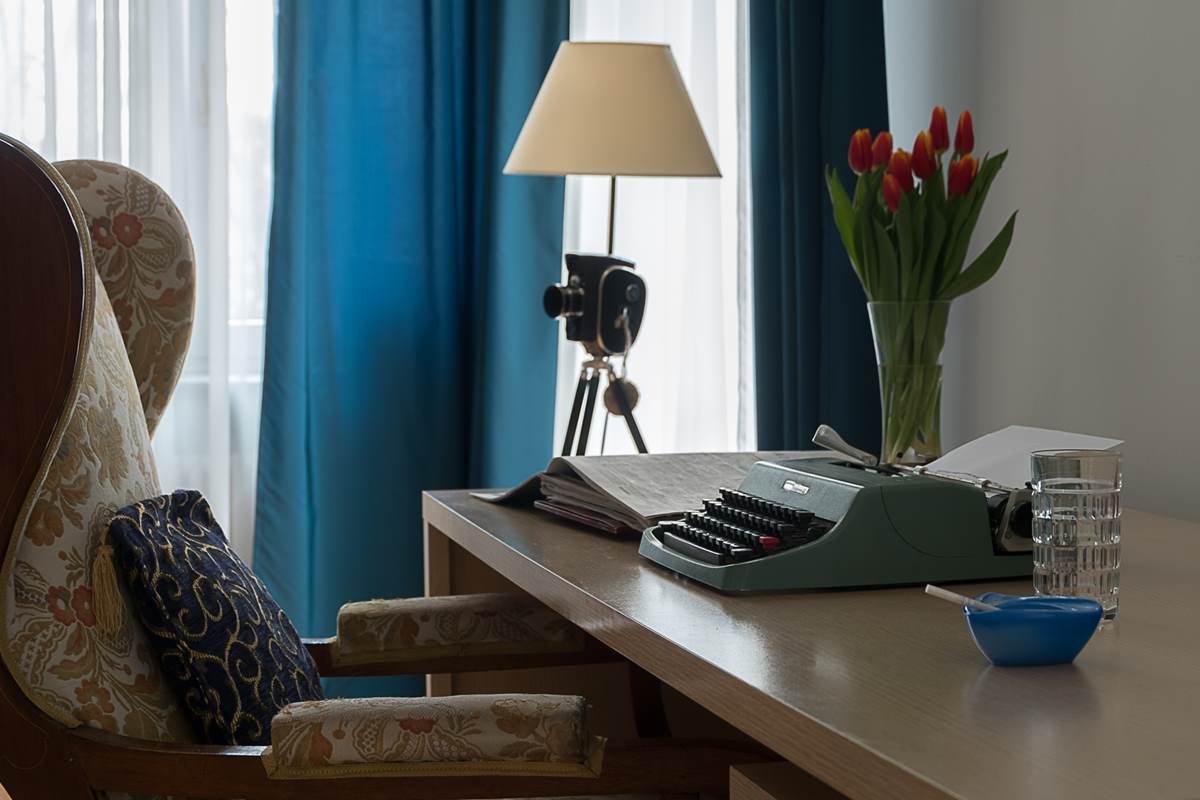 aranżacja mieszkania w kamienicy maszyna do pisania stary fotel wyposażenie wnętrz mieszkanie w kamienicy dodatki, które zrobią dobry klimat lampa aparat fotograficzny tulipany biurko ciekawe aranżacje wnętrz Jacek Tryc architekt